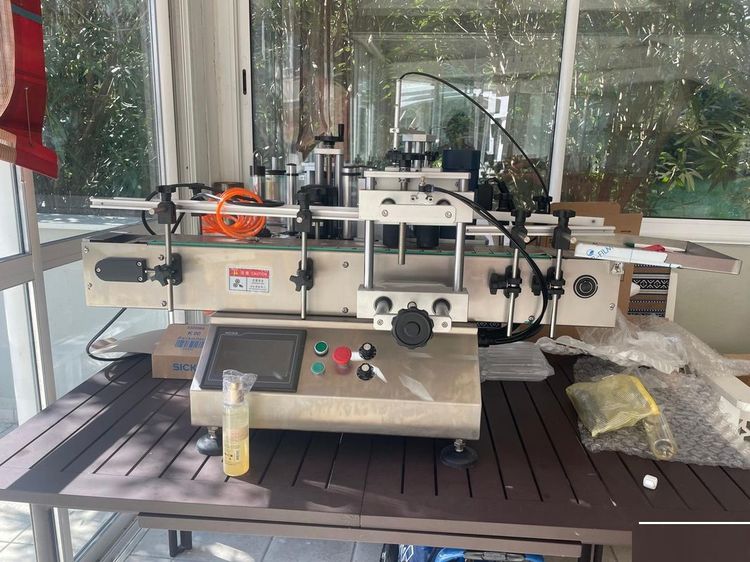 Automatic double-sided labeler for round bottles